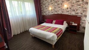 A hotel room with a bed, a nightstand, and a wall with a mosaic pattern. - Hôtel Fontaine Morlaix (Morlaix)