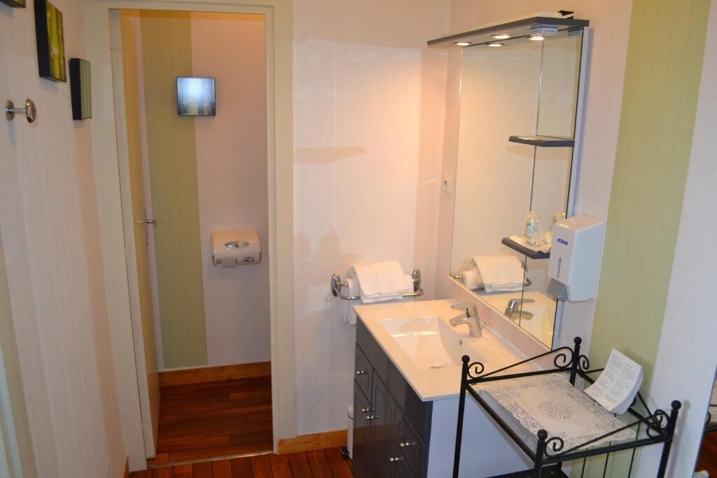 A bathroom with a white sink, a mirror, and a shower area.