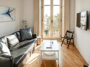 A modern living room with a leather sofa, a white coffee table, and a black chair.