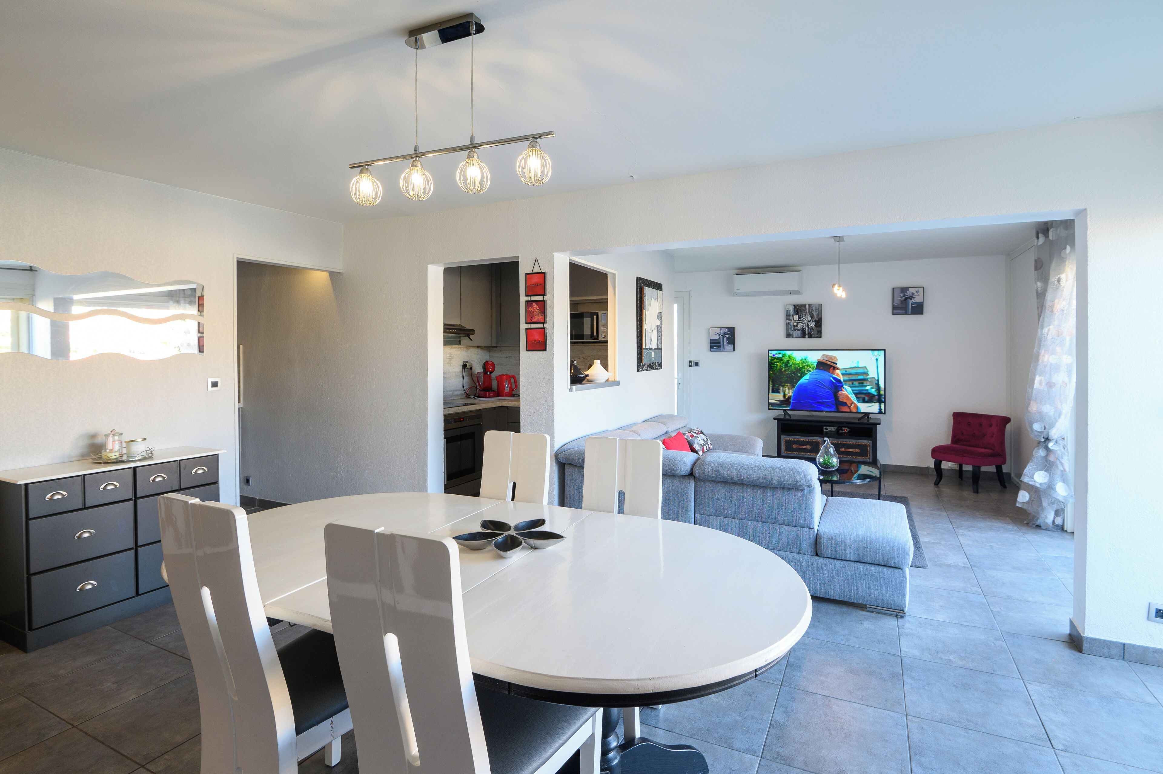 Une cuisine moderne avec un coin repas, un téléviseur et un canapé.