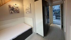 A modern interior with a bench, a refrigerator, and a hallway leading to an outdoor area. - Holiday apartment with WiFi, air conditioning and whirlpool (Siófok)