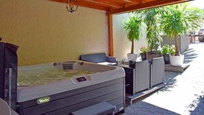 A hot tub with a control panel, seating area, and potted plants. - Holiday apartment with WiFi, air conditioning and whirlpool (Siófok)