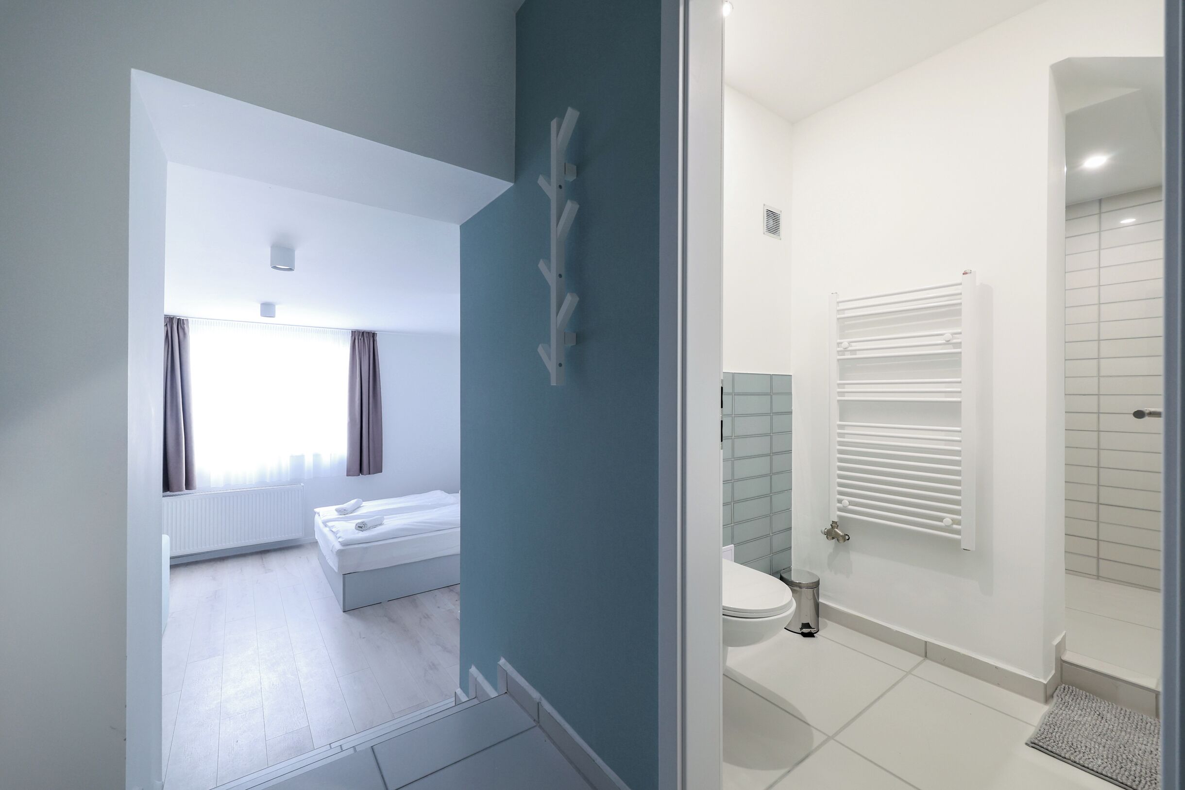 Un baño moderno con ducha, inodoro y radiador.