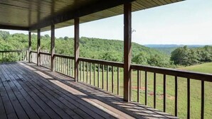A wooden deck with railings overlooking a forested landscape. - Branson White River Suite: A Private Forest Retreat (Reeds Spring)