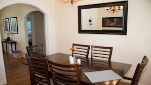 A dining area with a round table and four wooden chairs. - Yakima Vacation Rentals- Spacious Bungalow
 (Yakima)