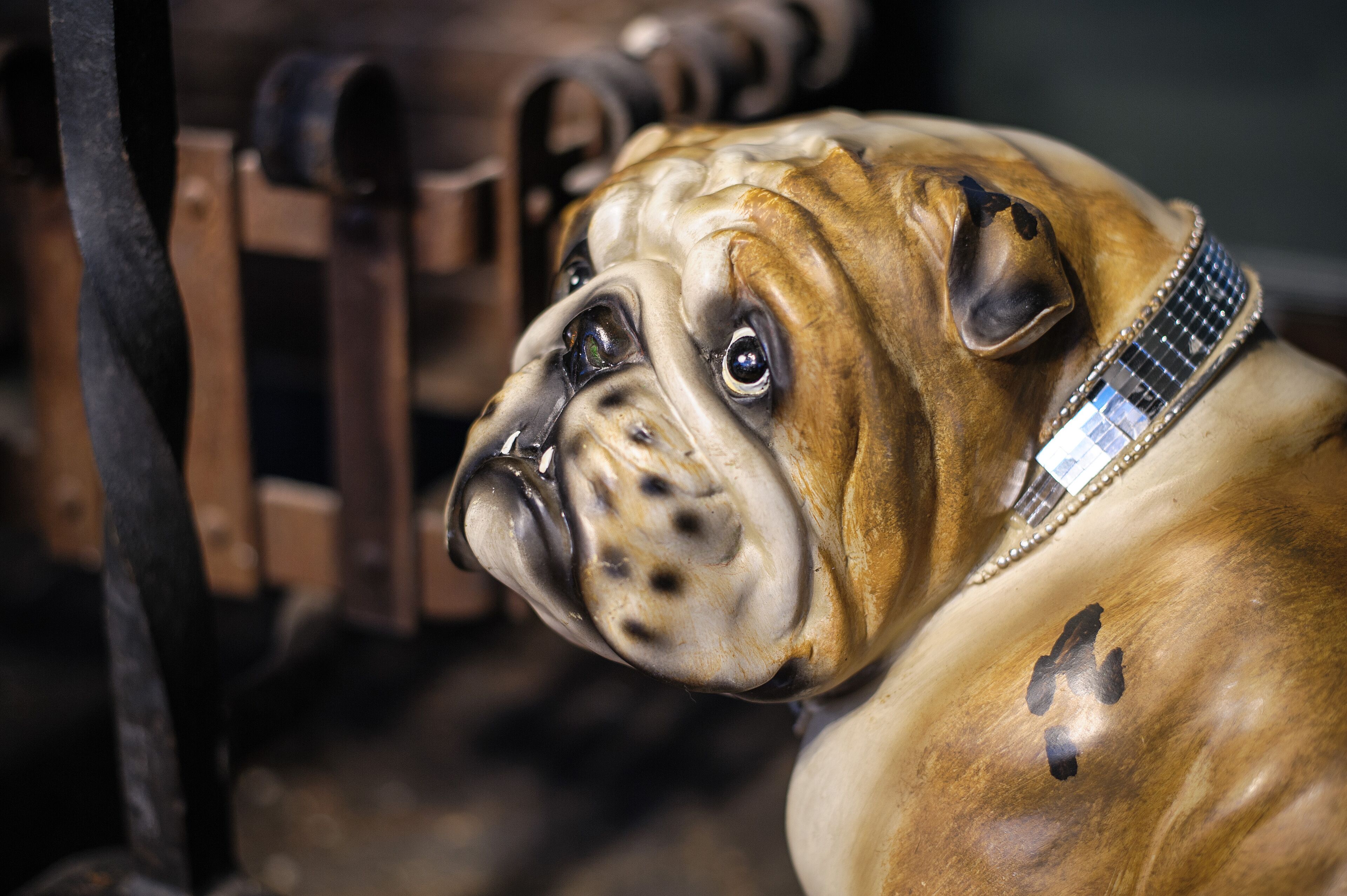 Una escultura de un bulldog con un collar brillante.
