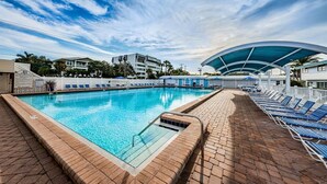 A swimming pool with lounge chairs, a covered area, and a clear sky. - Villa 22 - Premium Plus (Siesta Key)