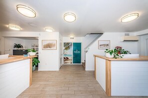 A modern hotel lobby with a reception desk, wooden flooring, and ceiling lights. - Villa 22 - Premium Plus (Siesta Key)