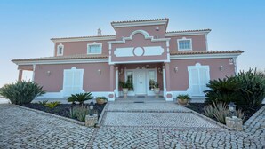 A large, two-story building with a symmetrical facade, a central entrance with a white door, and a tiled roof. - Al Meida Guesthouse (Albufeira)