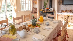 A dining area with a table set for breakfast, including plates, cups, and a variety of food items. - Al Meida Guesthouse (Albufeira)
