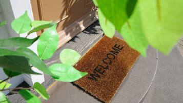 A brown doormat with "WELCOME" written on it, placed at the entrance of a building.