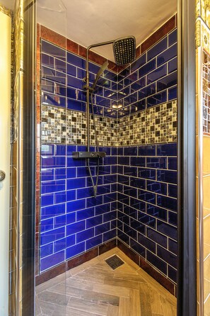 A shower with blue mosaic tiles and a wooden floor. - Luxury 3 Bed Manor House Hot Tub Cinema Room Skytv (Saffron Walden)