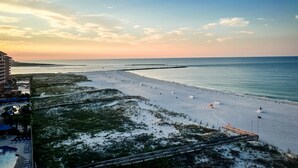 A beach with a long pier, a swimming pool, and a building with a balcony overlooking the beach. - Unwind by the Beach in Orange Beach! 4 bed/3bath - Sleeps 8 - Oceanfront View (Orange Beach)