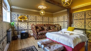 A bedroom with a large bed, a sofa, and a decorative wall. - Luxury 8 Bed Manor House Hot Tub Cinema Room Skytv (Saffron Walden)