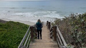 A wooden boardwalk leading to a beach with waves crashing onto the shore. - Fifth house from beach Avail June 14 - August18.  (Pismo Beach)