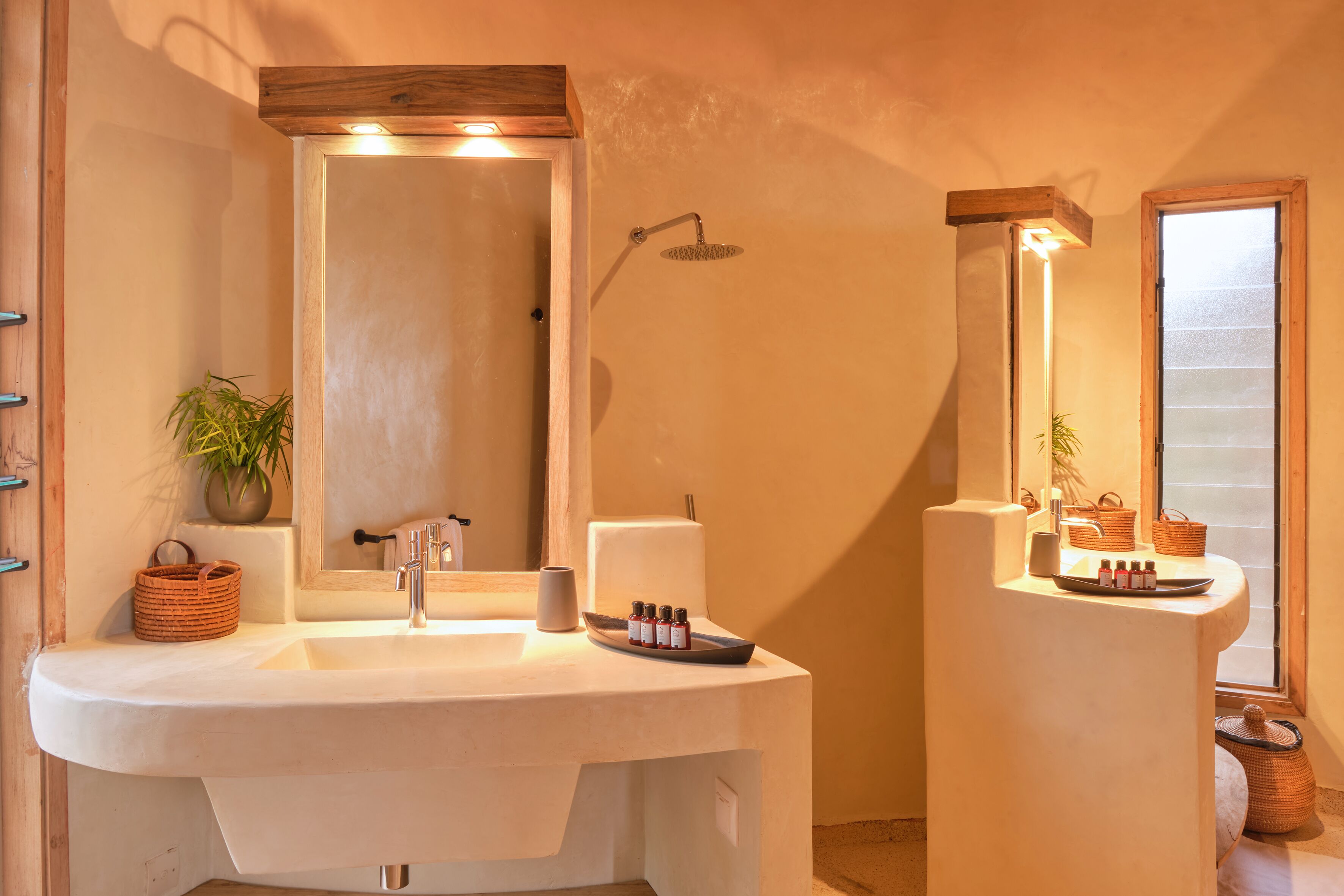 A bathroom with a large sink, a mirror, a shower, and a window.