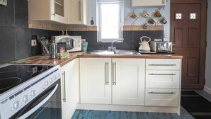 A kitchen with a stove, microwave, sink, and cabinets. - The Annexe, Llandysul (Penrhiw-llan)