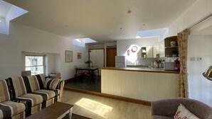Uma sala de estar moderna com um sofá, uma mesa de centro e uma área de jantar com mesa e cadeiras.
