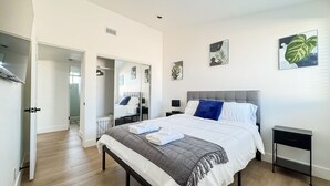A modern bedroom with a bed, bedside tables, a wardrobe, and artwork on the walls. - Enchanting Escape with Playground near Disneyland (Anaheim)
