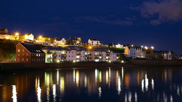A waterfront town at night with illuminated buildings reflecting on the water. - Seymour, Johnston - Two Bedroom Cottage, Sleeps 4 (Johnston)