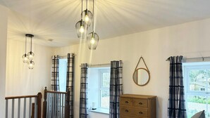 A bedroom with a bed, a dresser, a mirror, and a window with curtains. - Seymour, Johnston - Two Bedroom Cottage, Sleeps 4 (Johnston)