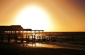A pier extending into a body of water with a building on the left side. - Townhouse, Aberystwyth (Aberystwyth)
