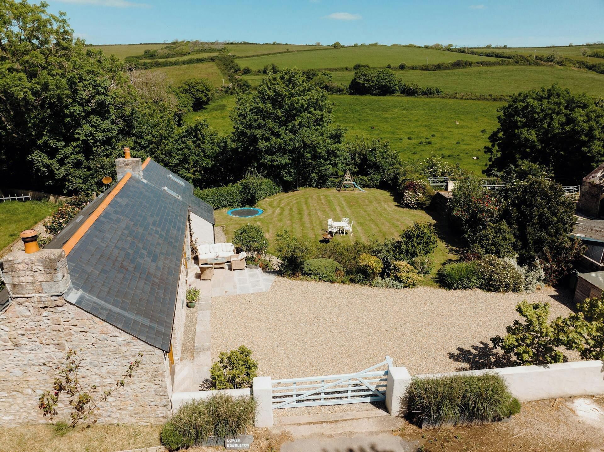 Une maison avec un toit en pente, une piscine et une pelouse bien entretenue.