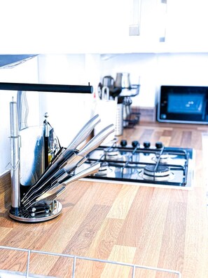 A modern kitchen with stainless steel appliances, a gas stove, and a digital display.