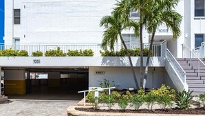 Un edificio con ingresso per parcheggio, una scala e una zona verde con piante.
