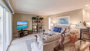 A living room with a television, sofa, coffee table, and decorative items.