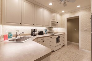 A kitchen with a stainless steel sink, a coffee maker, a toaster, and a microwave.
