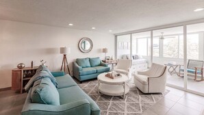 Un salon moderne comprenant un canapé, une table basse et un fauteuil.