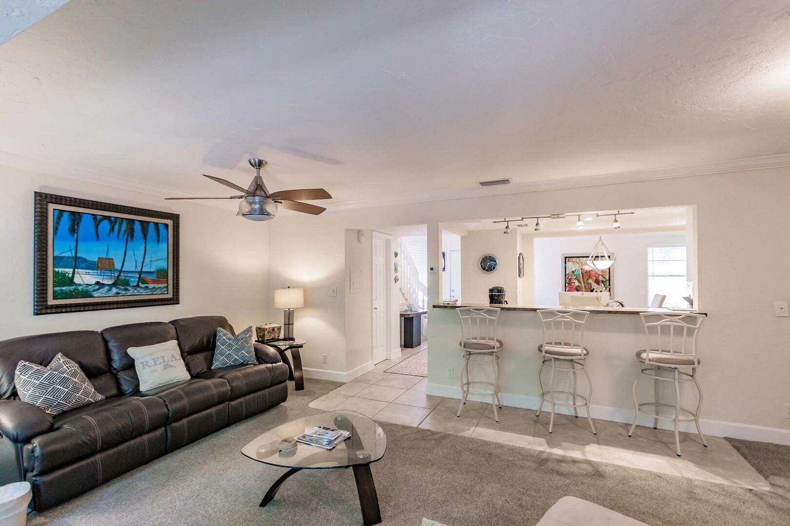 Un salon avec un canapé, une table basse et un ventilateur de plafond.