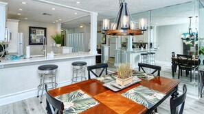 A modern kitchen with white cabinetry, a central island, and bar stools.