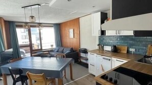 A modern kitchen with a black stove, white cabinets, and a blue backsplash. - 300m from ski slopes, 3rd floor, balcony, tv, ski locker, 52m², Tignes (Tignes)