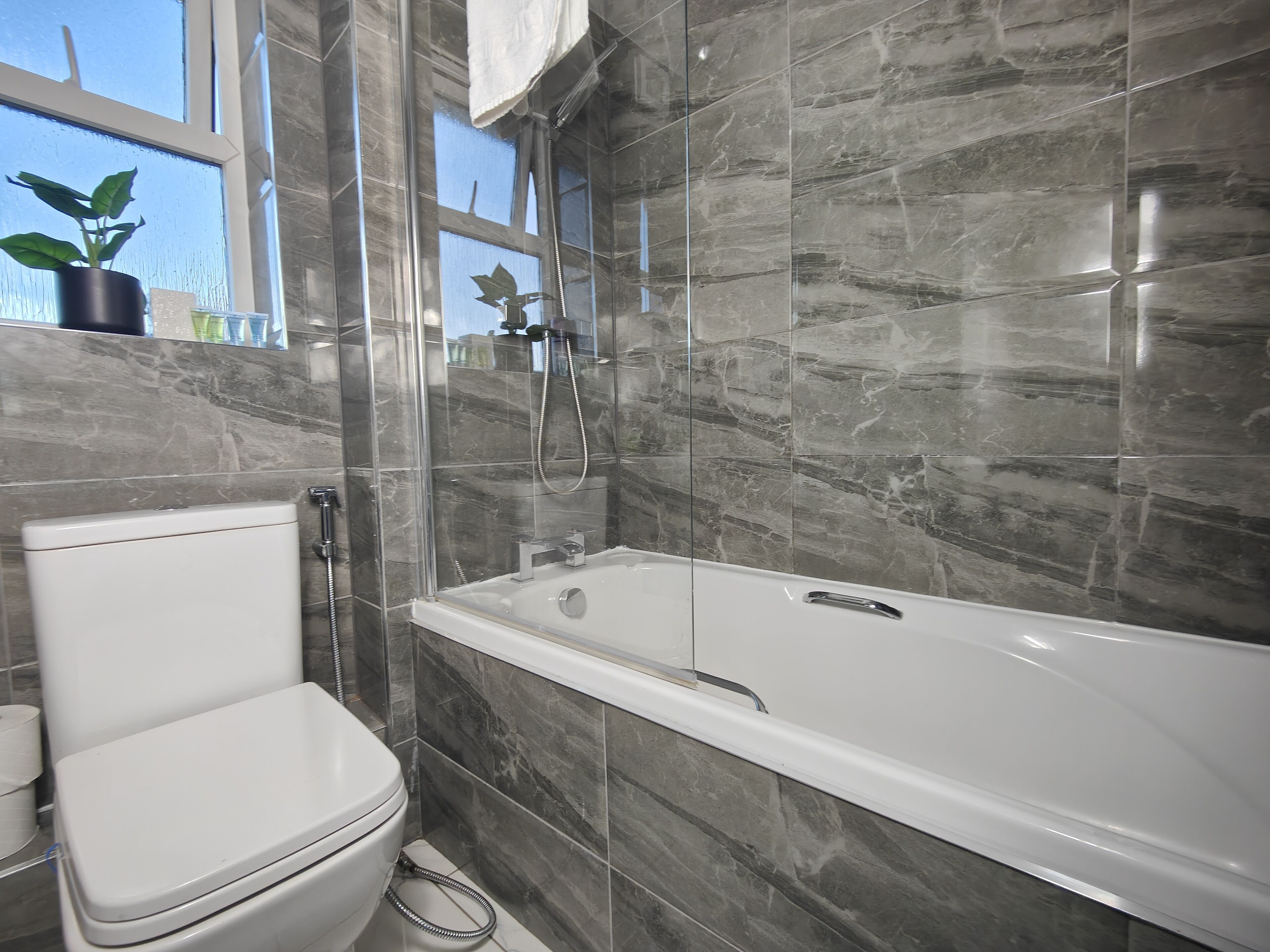 A bathroom with a toilet, a bathtub, and a shower.