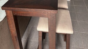 A rectangular wooden table with a dark finish, accompanied by matching wooden chairs with cushioned seats. - Marina on the Sakonett (Portsmouth)