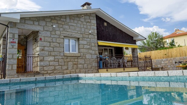 Ein Gebäude aus Stein mit einem Pool davor.