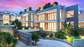 Un hôtel moderne à plusieurs étages, doté d’une allée incurvée et de jardins aménagés.