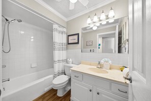 Een badkamer met een bad, toilet, wastafel en douche.