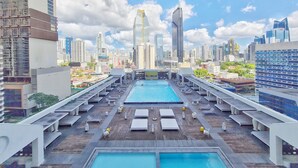 A rooftop pool area with lounge chairs and a view of the city skyline. - Yoo by Wynwood House (Panama City)