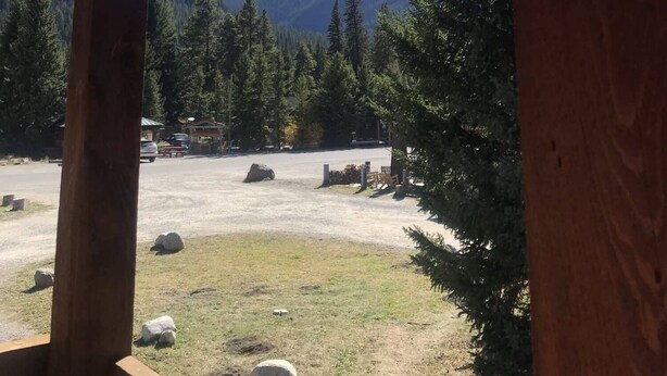 A wooden structure with a view of a mountain and forest. - Comfy cabin is situated on the Silver Gate property which overlooks 10,000ft tall mountain peaks surrounding the town. (SILVER GATE)