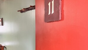 A room with a green wall, a red door, and a number '11' sign. - Newly Remodeled Motel Room with 1 Queen Bed, Bathroom with shower. Mini Fridge, Coffee Maker. Situated close to the General Store in Silver Gate, MT (SILVER GATE)