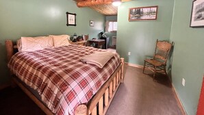 Un dormitorio con una cama de madera, un escritorio pequeño y una silla.