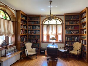 Una biblioteca con scaffali in legno, un tavolo e due sedie.
