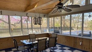 A covered patio with a checkered floor, wooden walls, and large windows. - Historic home in the heart of Poplar Bluff (Poplar Bluff)
