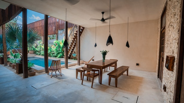 A spacious patio with a pool, wooden furniture, and a view of the outdoors. - Casa Mandarina, 4BDR by Cercana (Mérida)