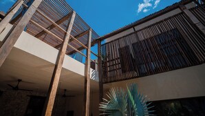 A modern building with a wooden structure and a large plant. - Casa Mandarina, 4BDR by Cercana (Mérida)