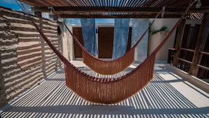 A hammock under a wooden pergola, a concrete wall, and a door with blue curtains. - Casa Mandarina, 4BDR by Cercana (Mérida)