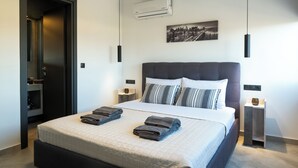A modern hotel room with a large bed, a cityscape painting, and a built-in wardrobe.